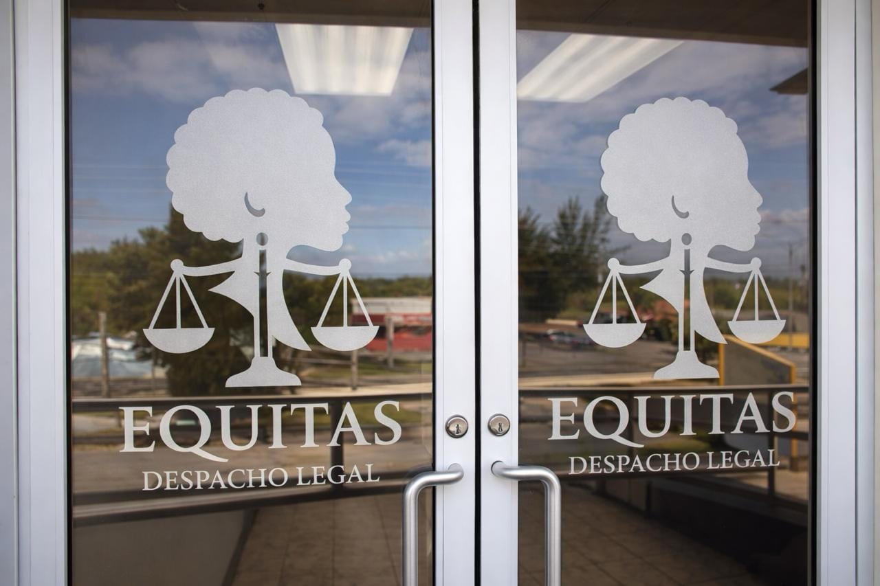 Entrada de la oficina, con las puertas de cristal y el logo de Equitas