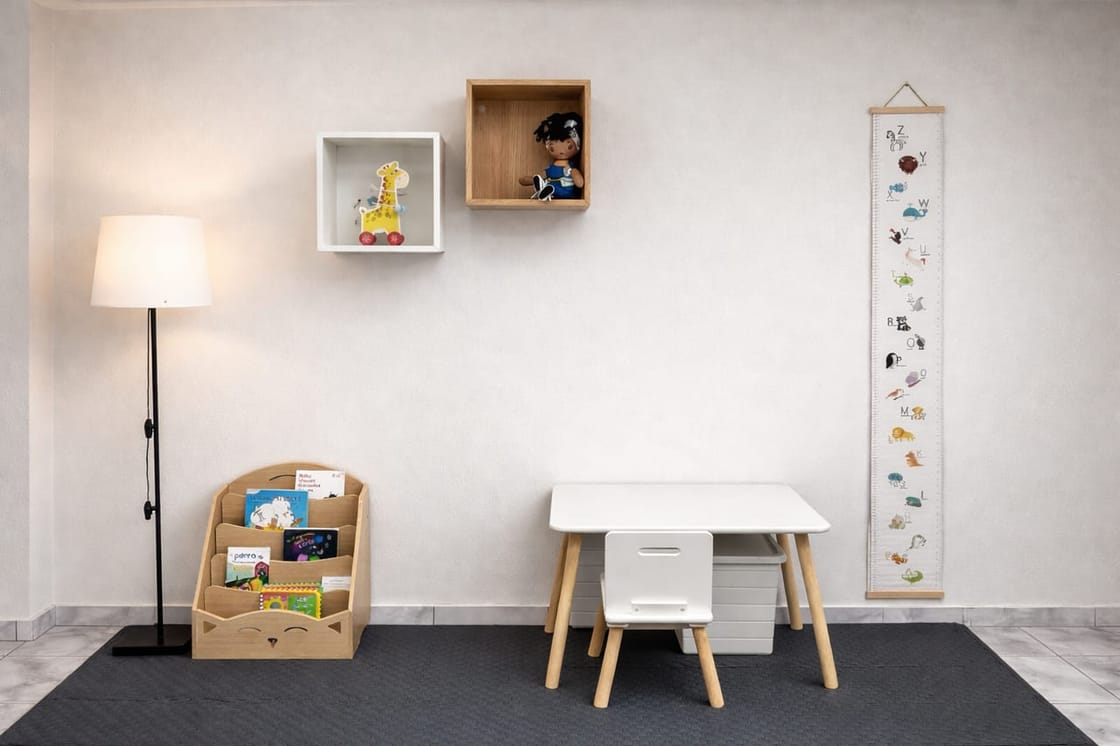 Play area with a children's table, books, and toys